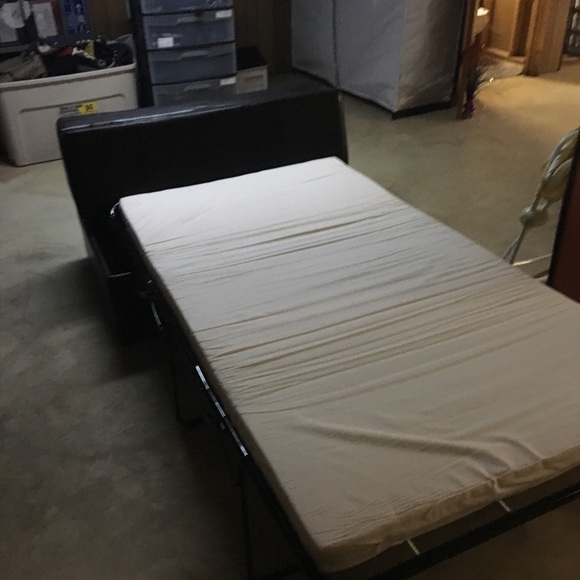 Black leather ottoman pulls out to a single bed.